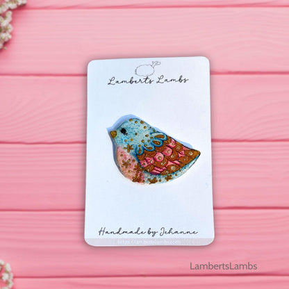 Hand painted bird brooch in blue pink and gold