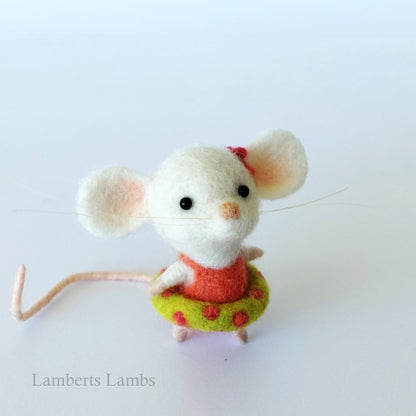 White needle felted mouse in an orange swimsuit with an inflatable ring.